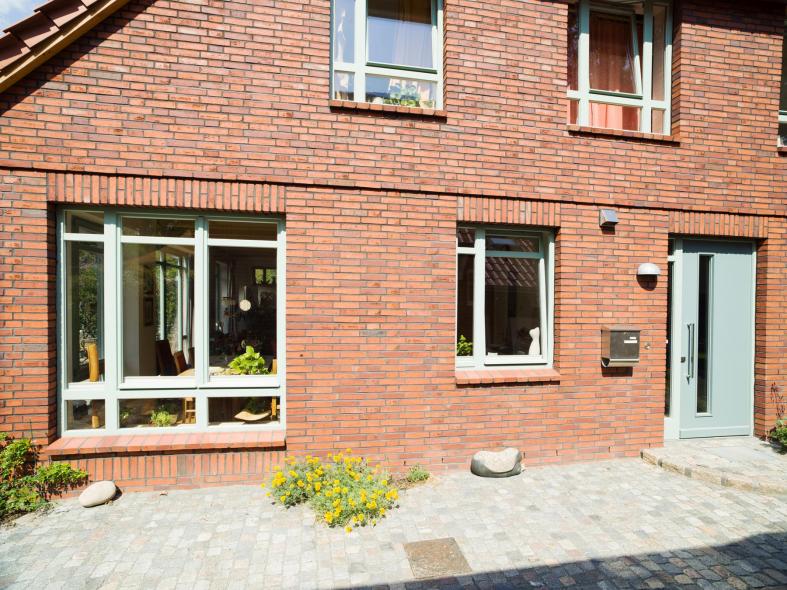 Holz-Haustür in türkis passend zu Fenstern